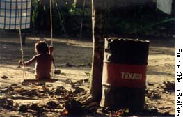 Child plays near Texaco barrel